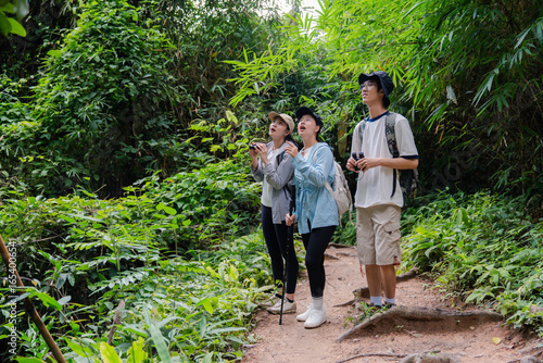 Foto Hikers observing wildlife with binoculars in lush jungle