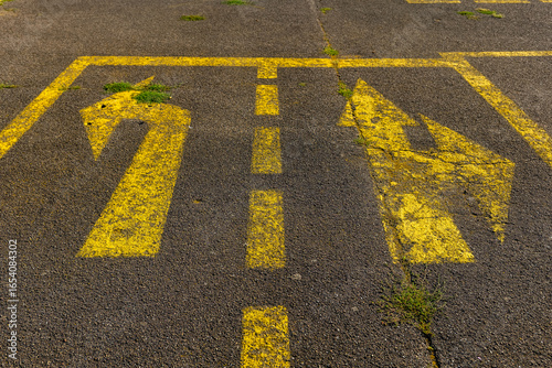 Navigating choices on an abandoned parking lot with faded directional lines in the warm light of late afternoon