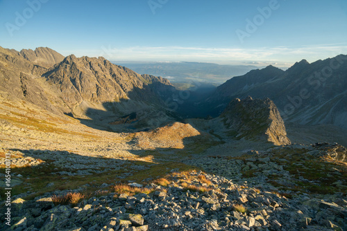 Aerial view of sunlight kissing the rugged peaks and valleys of the High Tatras, casting long shadows across the landscape, VysokÃ© Tatry, PreÅ¡ovskÃ½ kraj, Slovakia.