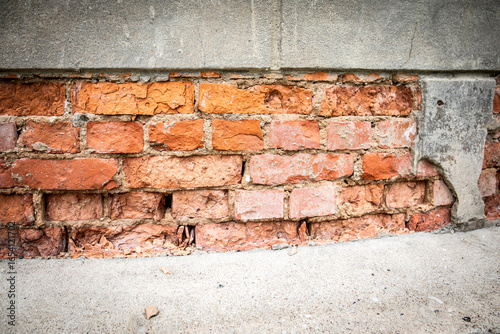 Old damaged brick wall with weathered mortar surface texture