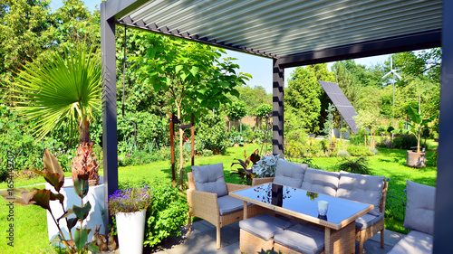 Modern aluminum pergola with stylish garden furniture in a beautiful garden.