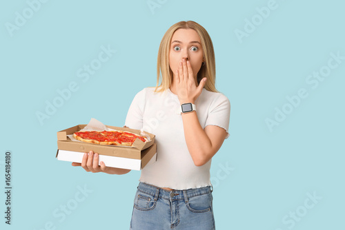 Young shocked woman holding...