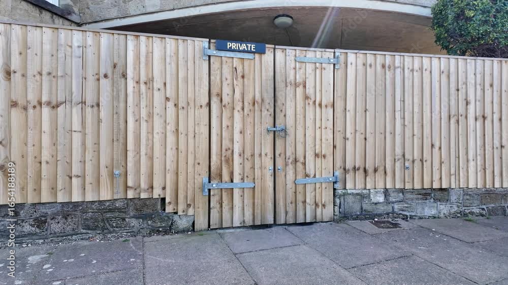 custom made wallpaper toronto digitalIsle of Wight United Kingdom. 10.08.2025.  Video. Wooden security fencing with padlocked double gate.