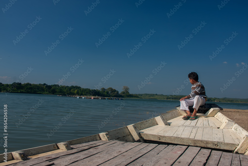young man sitting on a pier young man sitting on a pier