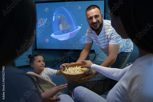 Happy family with popcorn w...