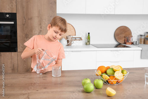 Cute little boy pouring wat...