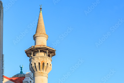 Wall Mural Historic mosque minaret against clear blue sky in daylight