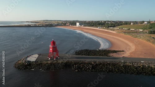 Static mid level drone clip of refurbished Herd Groyne Lighthouse with Littlehaven beach behind. Taken on a beautiful summer morning 