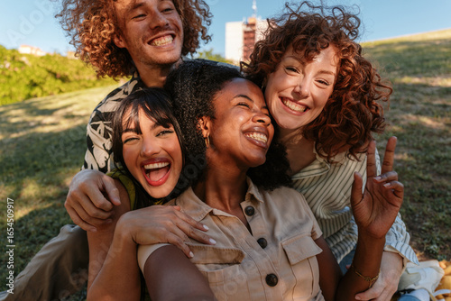 Canvastavla Happy friends embracing and smiling outdoors in a park