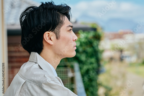 外を見つめる作業着姿の男性