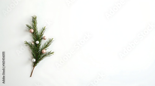 A simple and elegant Christmas background with a single fir branch and beautiful ornaments