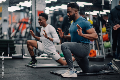 Panel kuchenny z motywem Two young men doing lunges and stretching in the gym