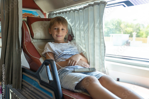 Fotografija Child, boy, traveling in a sleeper bus in Vietnam, bed seat in the bus, kid on v