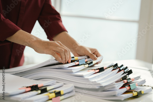 A cluttered office desk filled with paperwork, documents, files, and reports, symbolizing heavy workload, financial management, research, business tasks, corporate responsibilities, stress, and organi