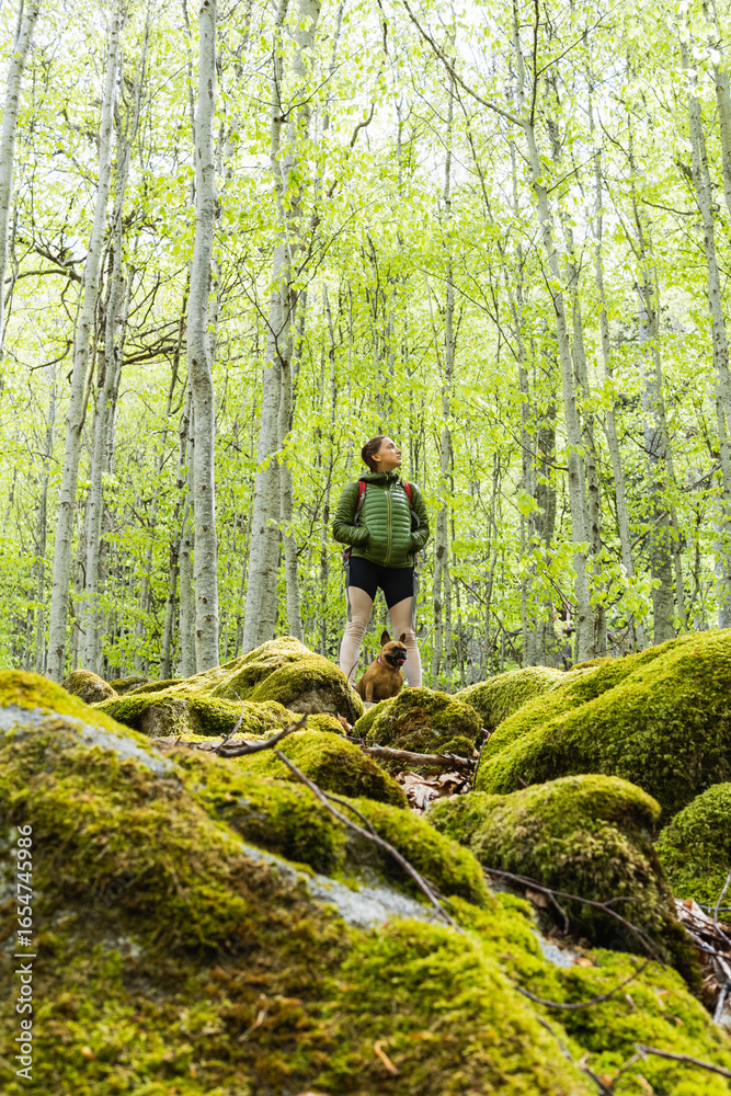 Naklejka premium Active young woman going hiking with dog