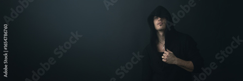 Fotografie Mysterious Hooded Man Portrait Wide Banner with Copy Space