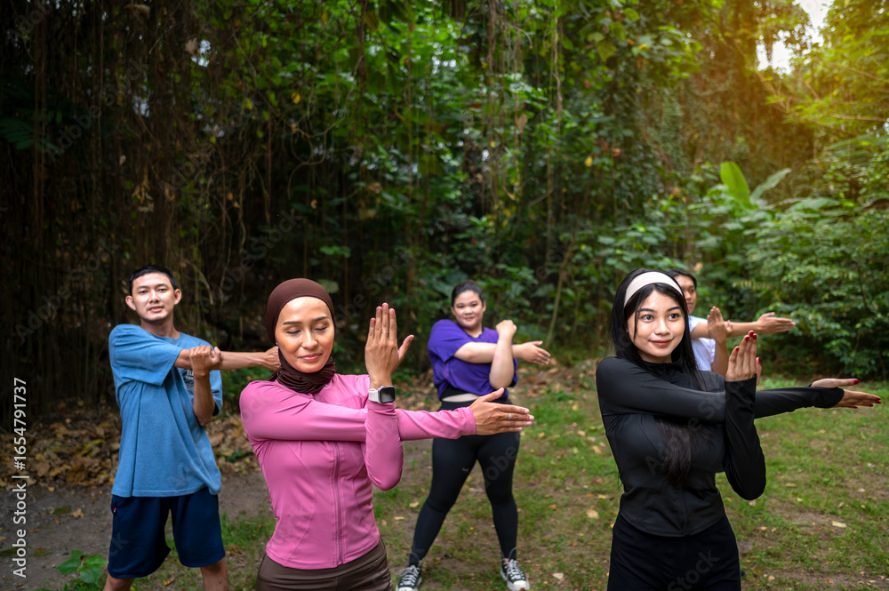 Obraz premium Indonesian southeast asian people in a sporty outfit practice exercise together in a public park outdoors. Concept of a Healthy active lifestyle