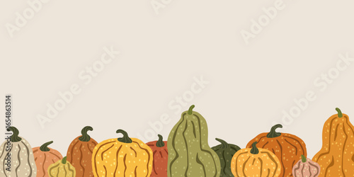 Colorful pumpkins forming a seamless border on a beige background