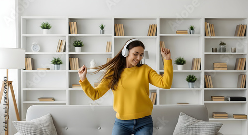Happy woman dancing to music with headphones at home enjoying favorite songs feeling relaxed and free