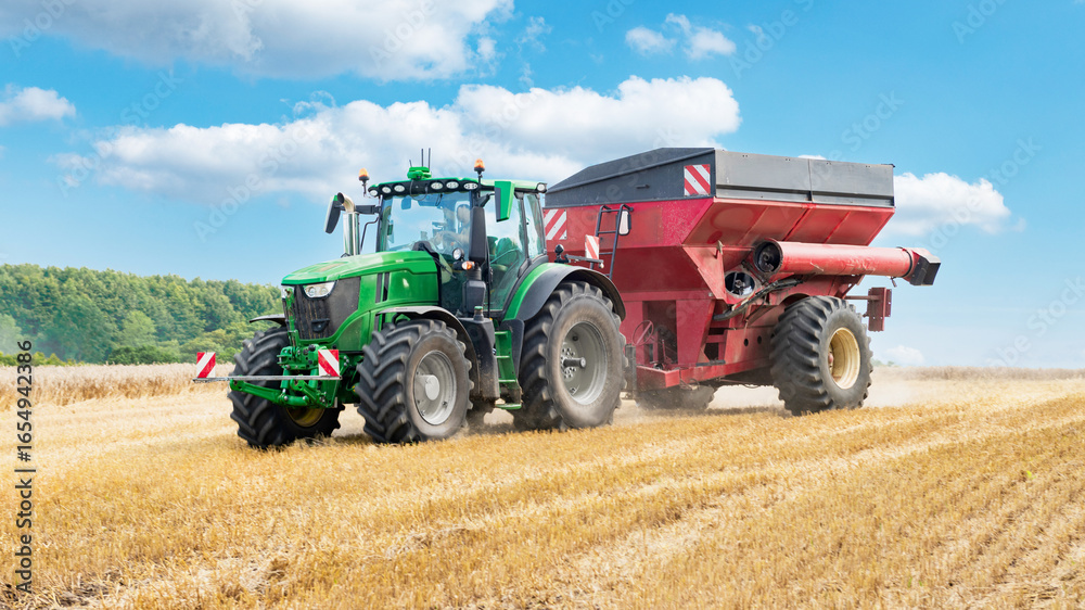 Obraz premium Tractor with trailer reloading grain onto a standing trailer - 3908