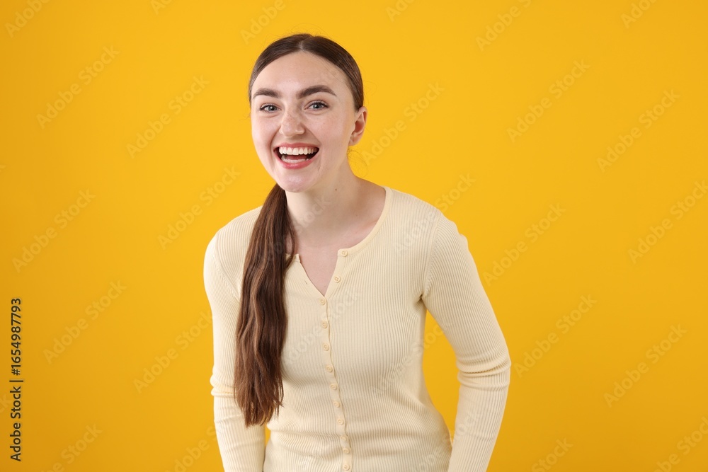Obraz premium Beautiful woman laughing on yellow background. Positive emotion