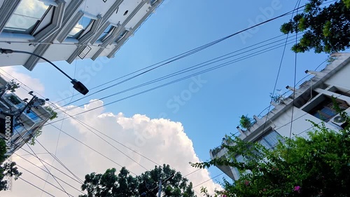 Clear blue sky framed by buildings and power lines

