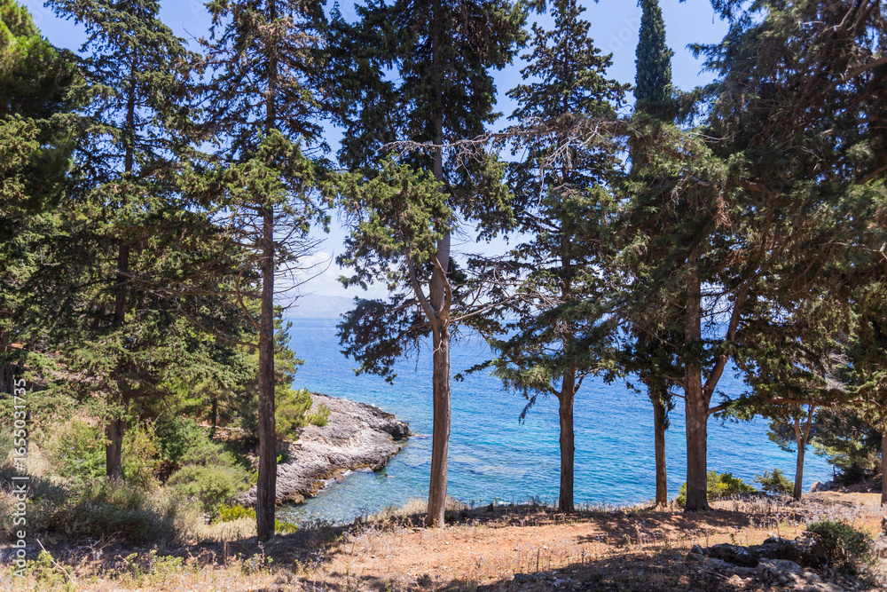 Fototapeta premium Historic Vido island coastline, known as Blue Tomb where Serbian soldiers were buried at sea during World War I, featuring pristine turquoise waters and memorial significance in Greek waters.