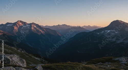 Mountain range at sunrise with a clear sky and shadowed valley
