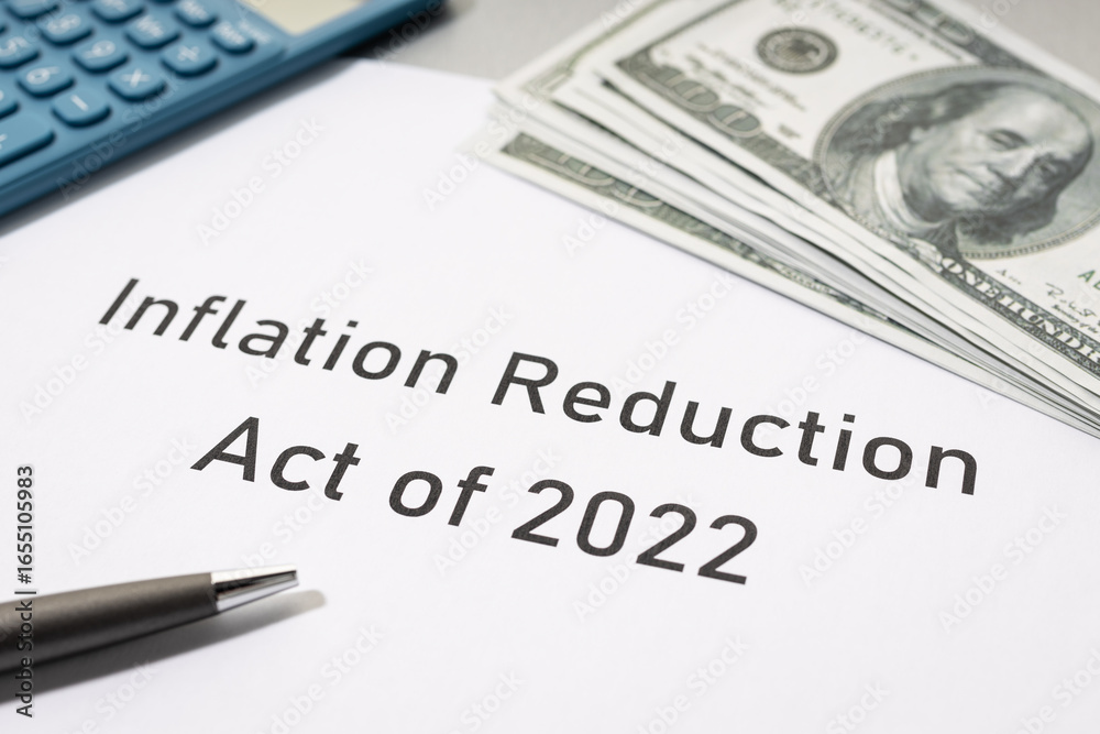 Fototapeta premium Inflation reduction Act concept. Document, dollar banknotes and calculator on desk