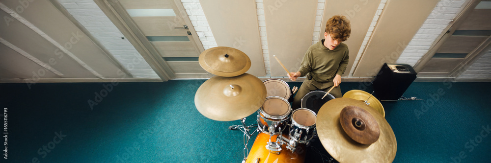 Obraz premium Young Drummer Playing Drums in Studio Wide Banner