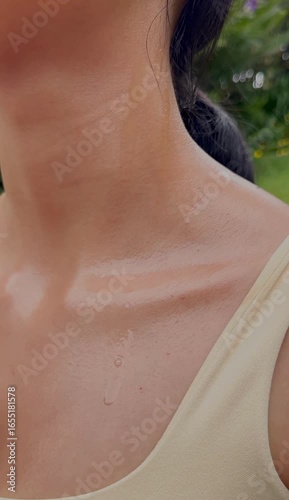 Close-up of woman’s shoulder with sweat and tan lines after outdoor physical activity.
