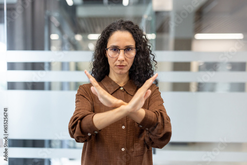 Obraz na plátně Confident woman gesturing refusal in modern office environment