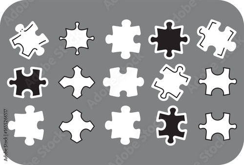 A collection of diverse puzzle pieces both black and white arranged in a grid pattern on a gray background showcasing various interlocking shapes