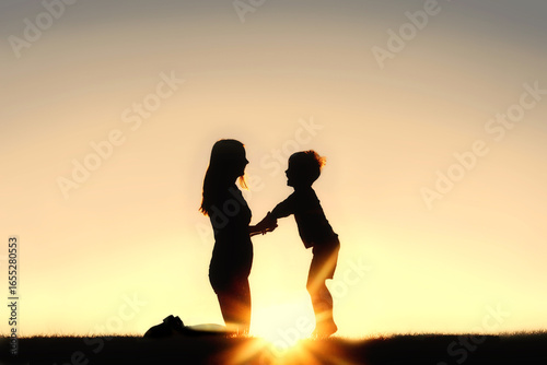 Silhouette of Mother and Young Child Holding Hands at Sunset