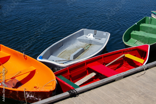 Φωτογραφία Colorful rowboats tied to dock on blue water