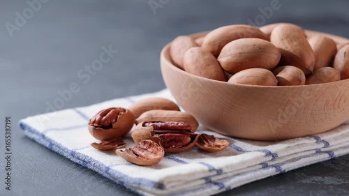  pecan in a wooden bowl on a black stone table. organic pecan in a bowl.