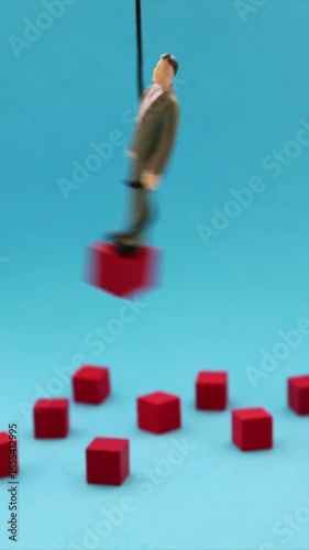 Leader balancing on a pendulum, red wooden cubes