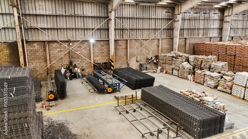 Interior de bodega industrial con materiales y camiones