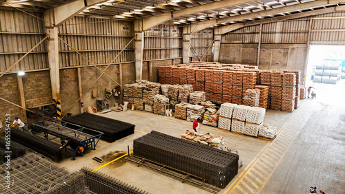 Interior de bodega industrial con materiales y camiones