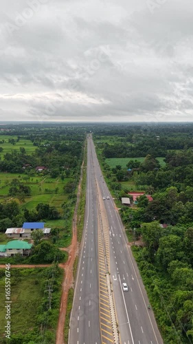 Scenic aerial view of a road next to rice paddies and a large river in Southeast Asia