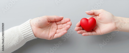 a woman and a man exchange a heart-shaped symbol against a clean gray background, a powerful concept representing medical care, health protection, and human connection