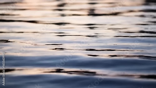 Abstract blurry close-up of gentle water ripples with reflections of the sky