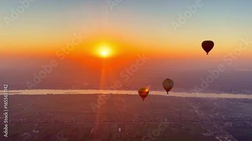 Hot air balloons flying along the Nile River and sunrise in Luxor, Egypt