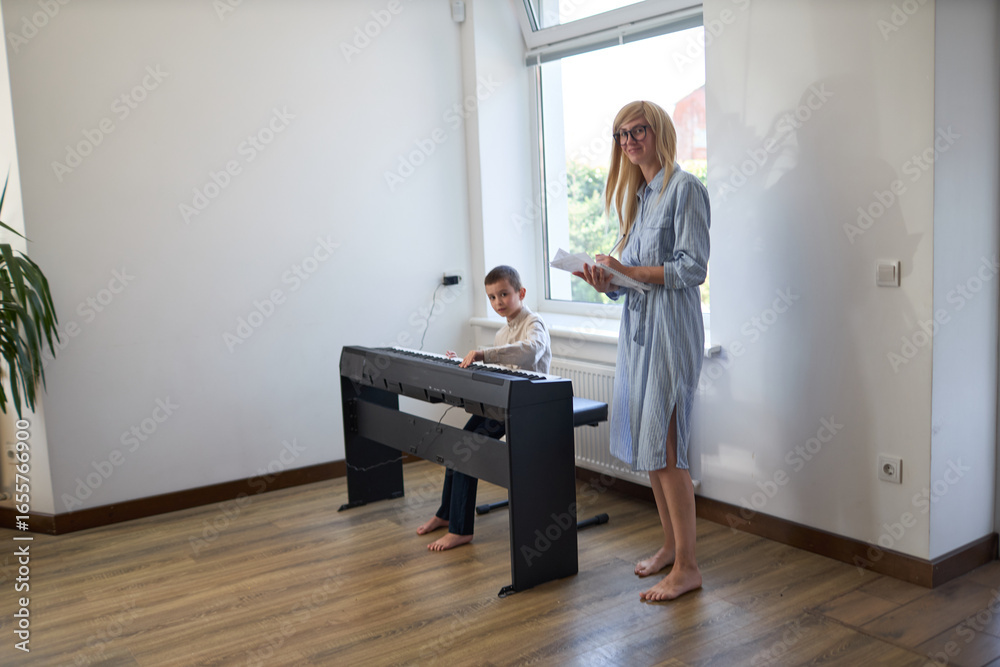 Fototapeta premium Music piano teacher and a boy learn how to play the piano