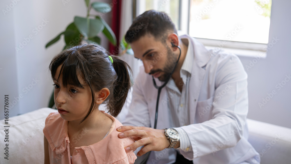 Fototapeta premium Young doctor examines girl in home environment.