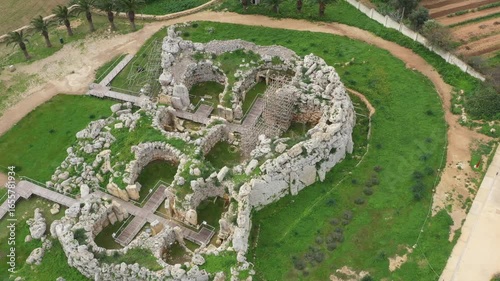 Drone shot of Ggantija Archaeological Park in Gozo with ancient stone temple ruins on green land