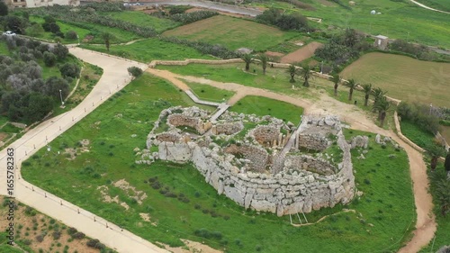Drone shot of Ggantija Archaeological Park in Gozo with ancient stone temple ruins on green land