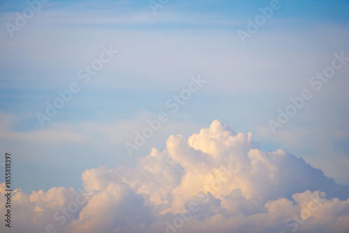 Fluffy cumulus clouds rise majestically along the horizon sky