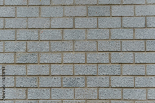 Light gray brick wall with rough, uneven texture. Repeating rectangular pattern creates a minimalist industrial feel.
