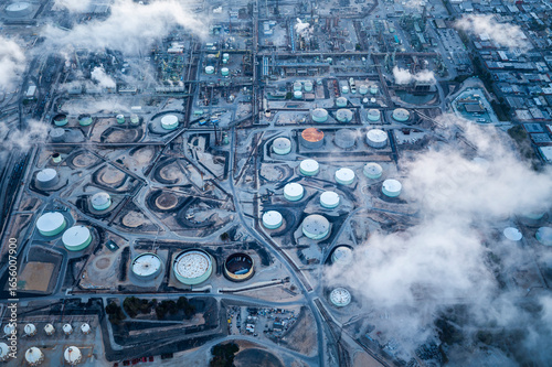 Aerial view of a large industrial zone with factories, storage tanks, and chimneys near the port area in Los Angeles, showcasing logistics, manufacturing, and heavy industry infrastructure